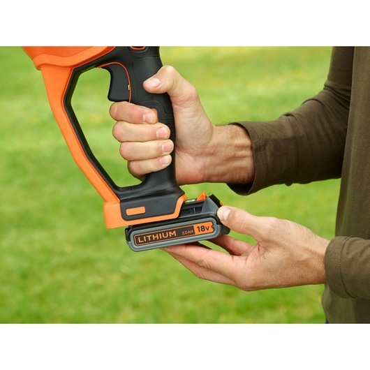 BLACKDECKER BCASK861D cordless tool handle with 18V lithium battery being inserted, close-up outdoors.