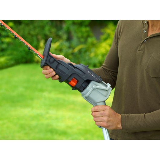 BLACKDECKER BCASK861D hedge trimmer being held outdoors, close-up on handle and blade.