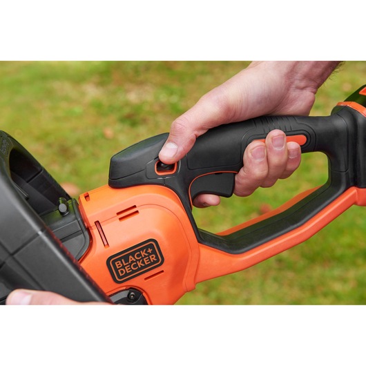 Photo of a BLACK+DECKER BCASK861D power tool handle in use, showing the black and orange grip details.