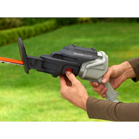 BLACKDECKER hedge trimmer handle, BCASK891D, close-up in outdoor garden setting.
