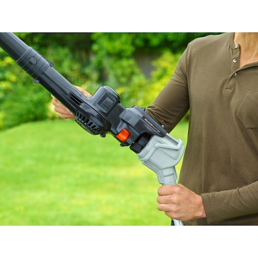 BLACK+DECKER BCASK8967D2 garden tool being held outdoors, close-up showing handle and attachment.