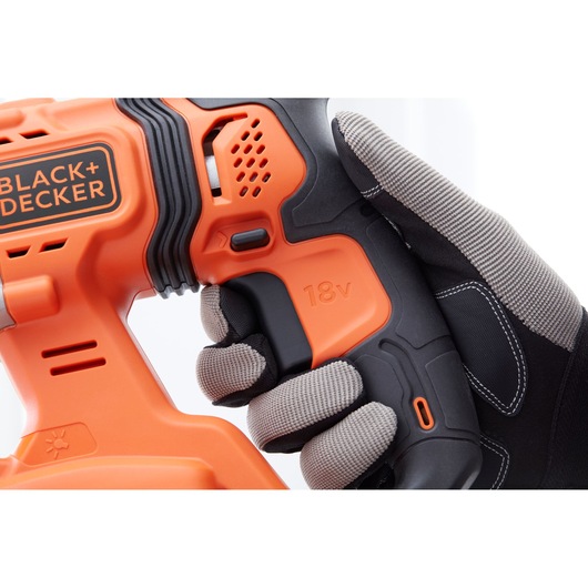 Close-up photo of BLACK+DECKER BCD900D1S cordless power drill with 18V marking, held by a gloved hand.