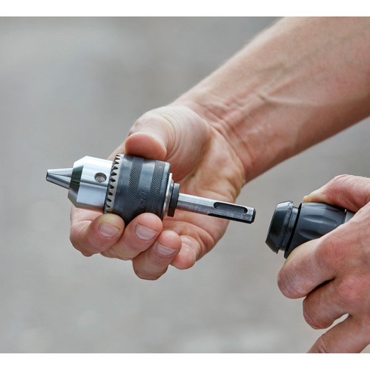 Closeup photo of BLACKDECKER BCD900M1K drill chuck attachment being held in hands.