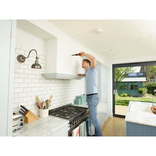 Photo of BLACKDECKER BCF601C cordless screwdriver used in modern kitchen above stove.