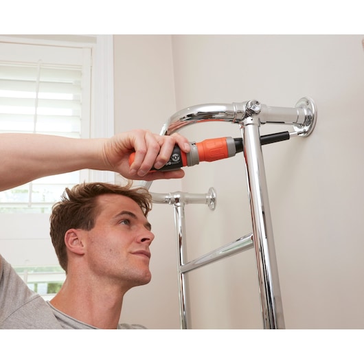 BLACKDECKER BCF602C cordless screwdriver used to install chrome wall fixture in home interior.