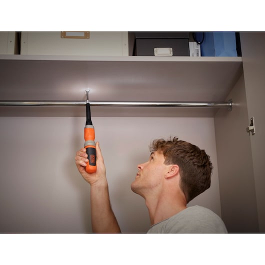 Person using BLACK+DECKER BCF602C cordless screwdriver to install a screw inside a closet.
