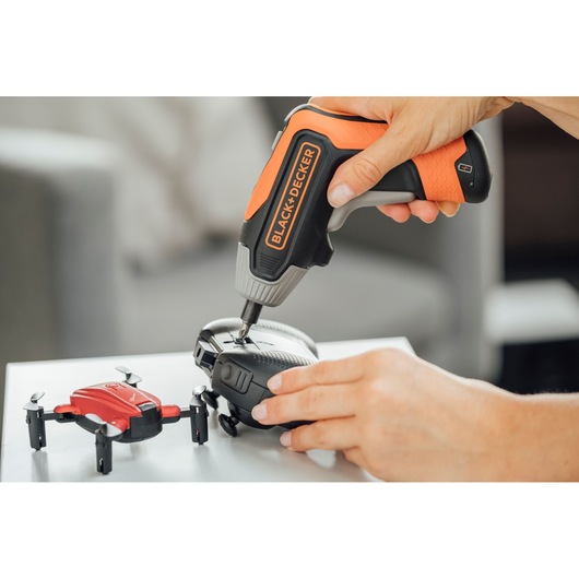 Photo of BLACK+DECKER BCF611CK cordless screwdriver repairing a black drone, red drone shown nearby.