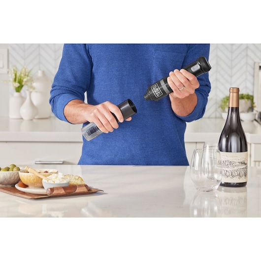 Photo of BLACKDECKER BCKM1012KB electric pepper grinder in use on a kitchen counter near wine and appetizers.