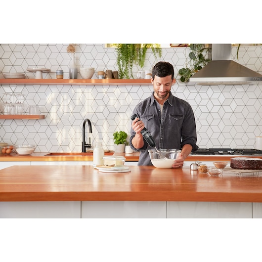 BLACKDECKER BCKM1016KSB hand mixer used in modern kitchen near bowl and baked goods.