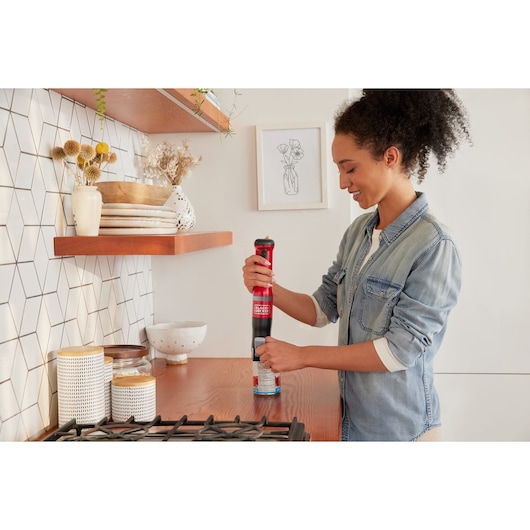 Photo of BLACKDECKER BCKM1016KSR cordless kitchen tool in red, used on a countertop near stove.