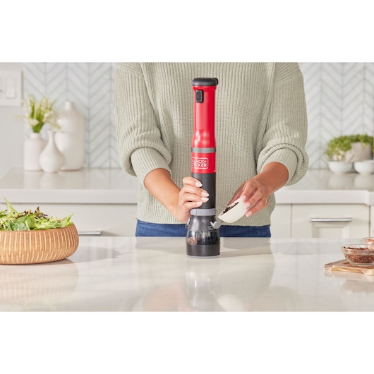 Photo of BLACK+DECKER BCKM1016KSR electric grinder in red and black, used in a kitchen to grind spices.