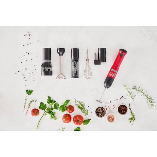 Photo of BLACK+DECKER BCKM1016KSR hand blender set with various attachments, herbs, tomatoes, and spices on white background.