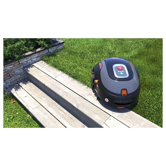 BLACKDECKER BCRMW123 robotic lawn mower on grass near wooden steps, top view photography.