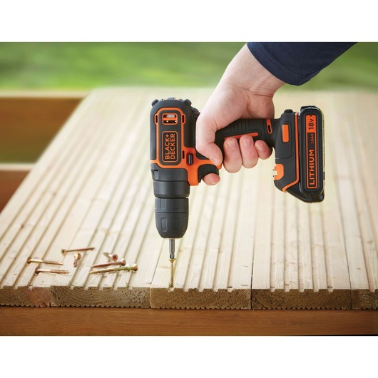 BLACKDECKER BDCD18K cordless drill driving a screw into wooden planks, close-up side angle.