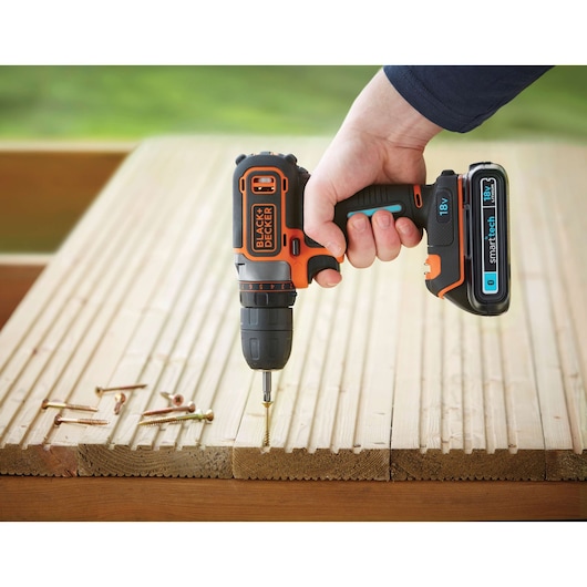 BLACK+DECKER BDCDC18KST cordless drill in use driving screw into timber decking.