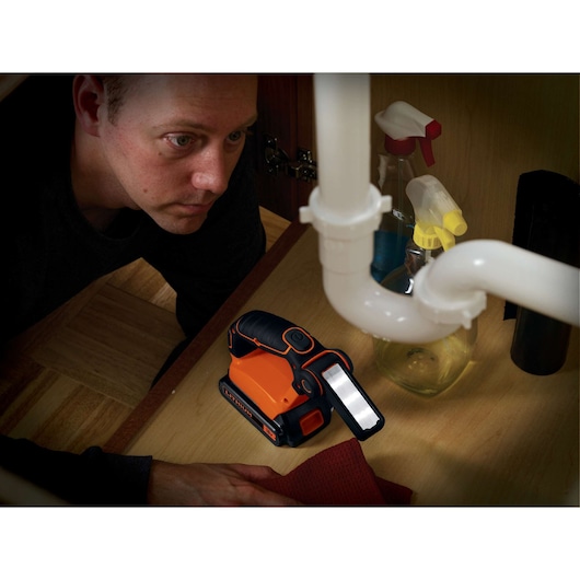 Photo of BLACKDECKER BDCF18 flashlight under sink, with spray bottles and cleaning cloth nearby.