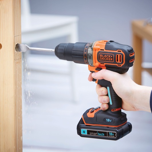 Photo of BLACK+DECKER BDCHD18KBST cordless drill with 18V battery drilling into wood.