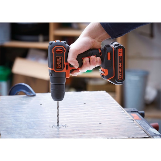 BLACKDECKER BDCHD18KB2 cordless drill in use, drilling metal surface, close-up photography.