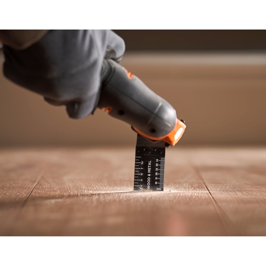 BLACKDECKER BDCOS18N oscillating tool cutting wood floor, close-up photography.