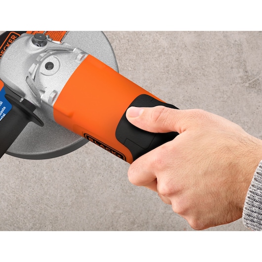 Photo of a hand holding a BLACKDECKER BDGL2223 angle grinder with orange and black body, close-up view.