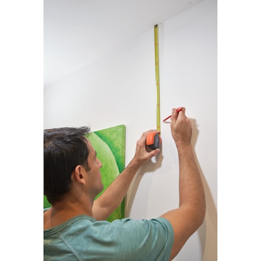 Photo of BLACKDECKER BDHT84002 tape measure being used to mark measurement on white wall.