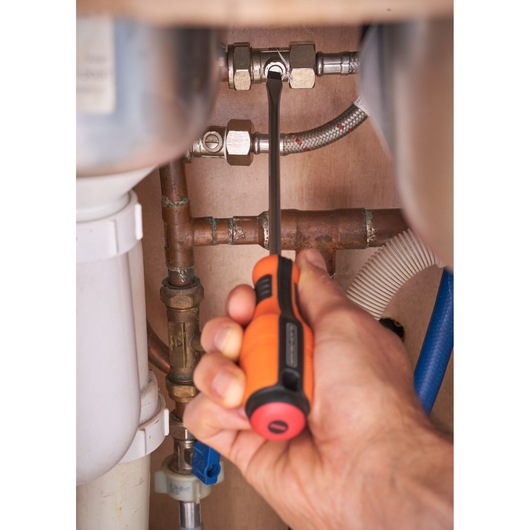 BLACKDECKER BDHT84014 orange and black screwdriver used on metal pipe under sink.