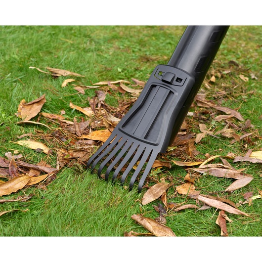 BLACKDECKER BEBLV301 leaf blower tube with claw attachment on grass and dried leaves, close-up.