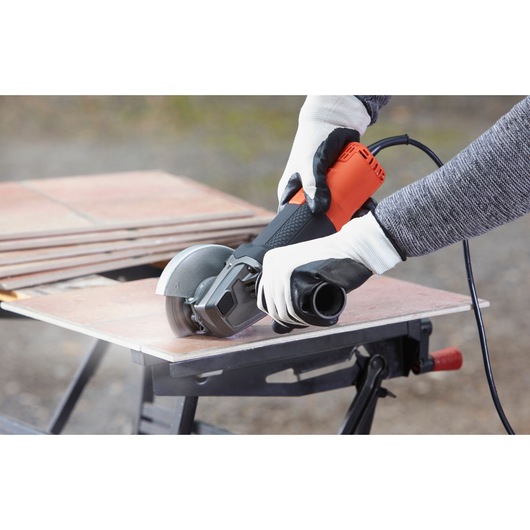 Photo of BLACKDECKER angle grinder BEG220 cutting tiles outdoors.