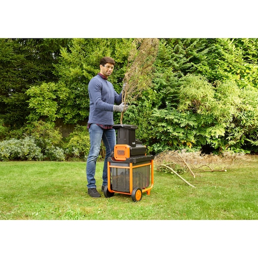 BLACKDECKER BEGAS5800 garden shredder with orange frame and wheels in use outdoors.