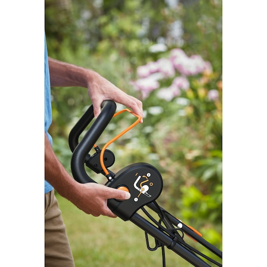 BLACKDECKER BEOEP320-QS lawn mower handle and control panel in close-up with orange lever outdoors.