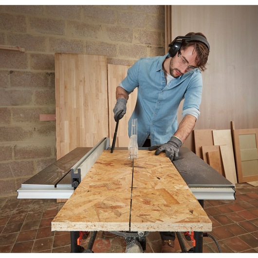 BLACKDECKER BES720 table saw cutting plywood in workshop, photo shows tool in use with safety gear.