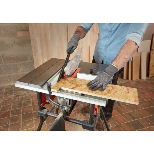 BLACKDECKER BES720 table saw in use, cutting wood, close-up angle in workshop setting.