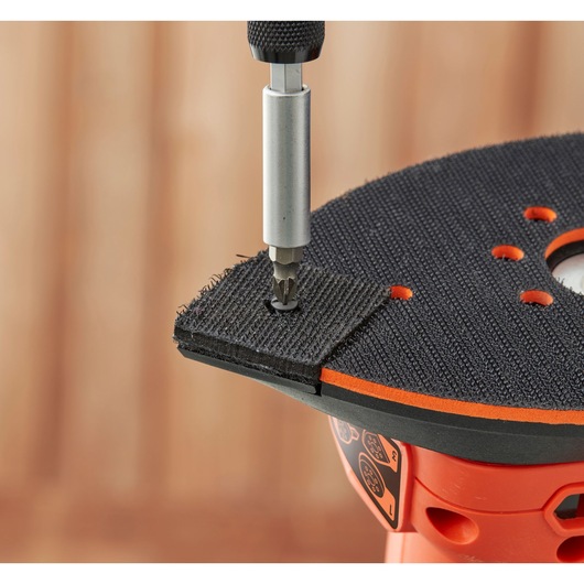 BLACKDECKER BEW200 detail sander with screw bit attaching Velcro pad, close-up angle.