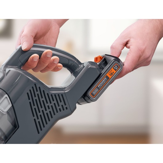 BLACKDECKER BHFEA18D1 cordless vacuum close-up showing battery being inserted into handle.