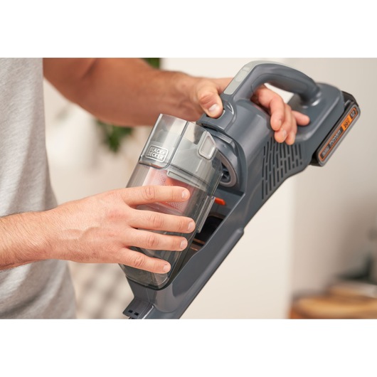 Photo of BLACKDECKER BHFEA18D1 cordless vacuum cleaner, close-up of hand removing dust container.