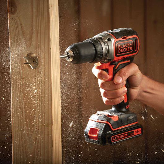BLACK+DECKER BL186KB cordless drill used on wood, 18V lithium battery, close-up action shot.