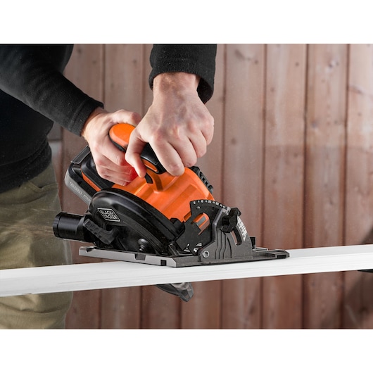 Photo of BLACKDECKER BLCCS78M1 circular saw cutting wood plank, in use, orange and black tool.