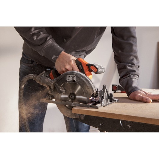 BLACK+DECKER BLCCS78M1 circular saw cutting wood, handheld, close-up of action, dust extraction hose attached.