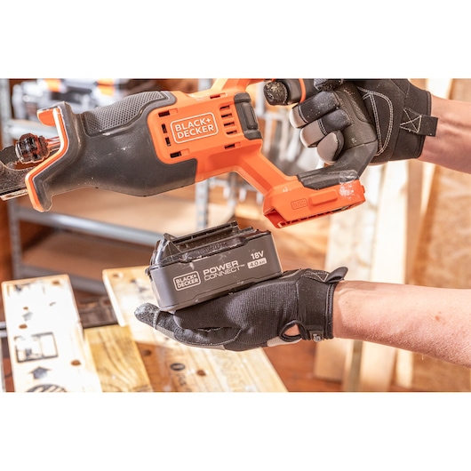BLACK+DECKER BLCR78M1 orange and black reciprocating saw with 18V 4.0Ah battery, close-up in workshop.