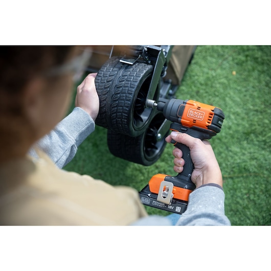 Photo of BLACKDECKER BLIM78E1K cordless impact driver being used to tighten wheel bolts outdoors.