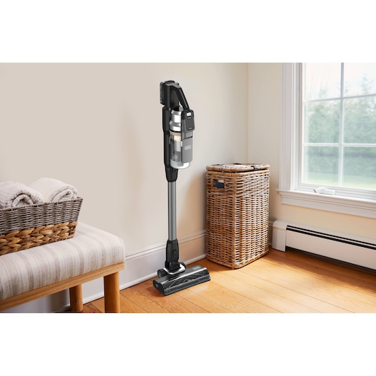 BLACKDECKER BSV520BL2P cordless stick vacuum cleaner standing upright in a bright room with wooden floor.