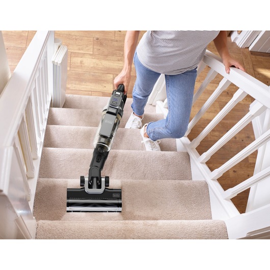 Photo of BLACKDECKER BSV525BLP cordless vacuum cleaner being used on carpeted stairs.