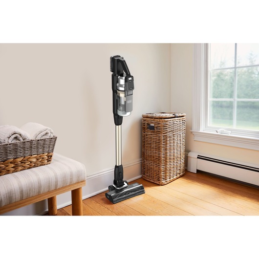 BLACKDECKER BSV525BLP cordless stick vacuum cleaner standing upright in a bright, tidy living room corner.