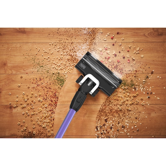 BLACKDECKER BSV525BRP stick vacuum cleaning debris on hardwood floor, top view.