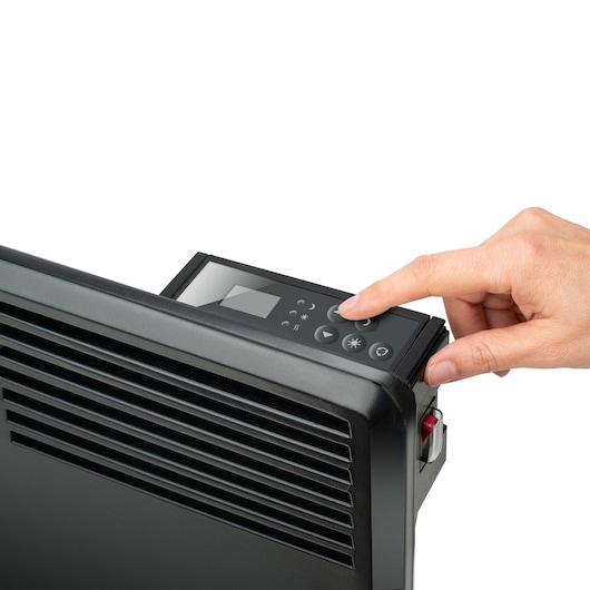 BLACKDECKER BXCSH1800E electric heater close-up with hand using digital control panel, front angle, black finish.