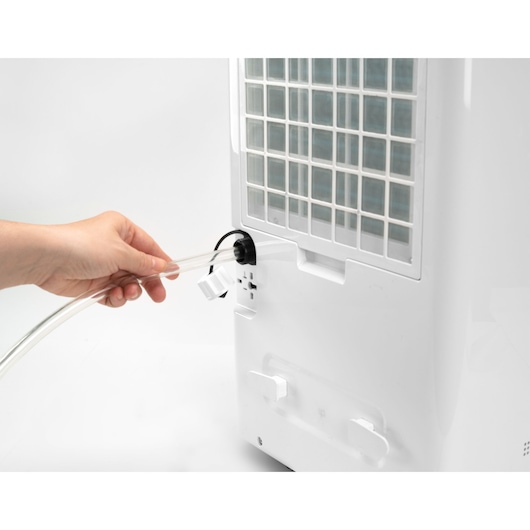 BLACKDECKER BXDH20E dehumidifier back view with hand connecting drain hose.