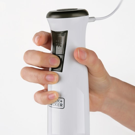 Photo of BLACKDECKER BXHBA600E hand blender in use, close-up of control buttons on white body.