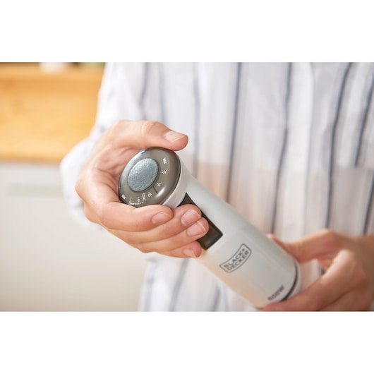 Photo of BLACKDECKER BXHBA600E hand blender with adjustable dial held in hand, white and silver finish.
