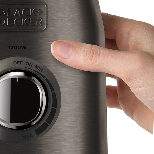 Photo of BLACKDECKER BXJB1200E blender control knob, close-up with hand adjusting settings.