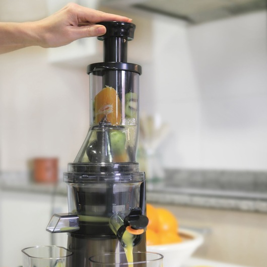 BLACKDECKER BXJE200E juicer extracting juice from fruits in a kitchen setting, front angle.